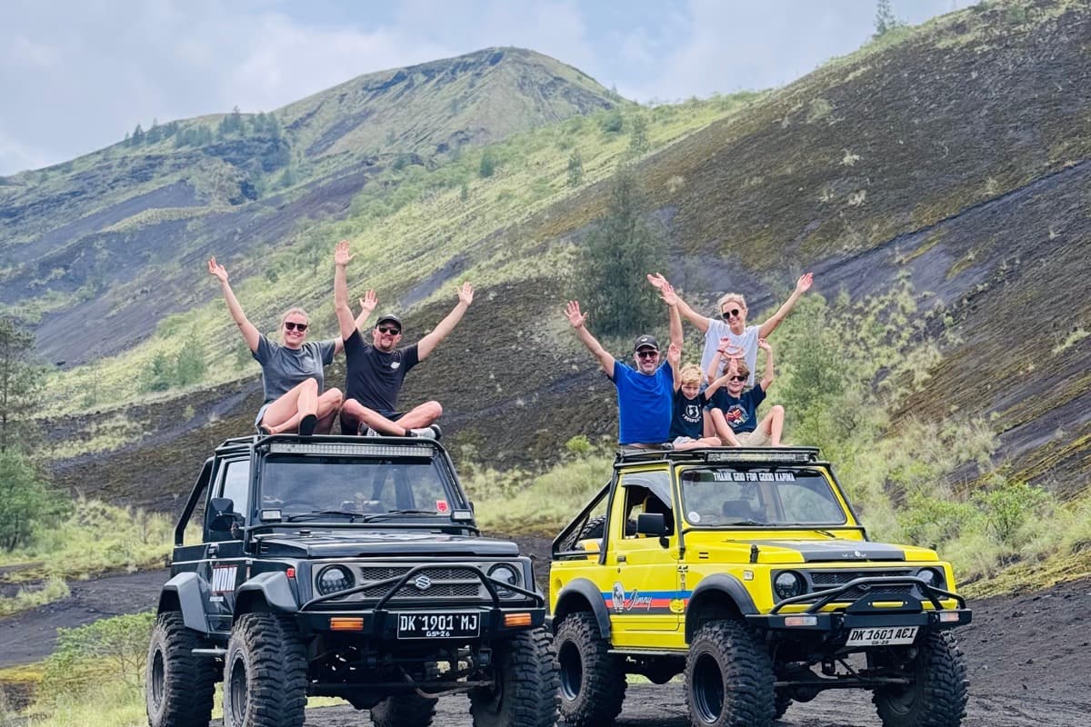 Group celebrating on two 4x4 jeeps below Mount Batur