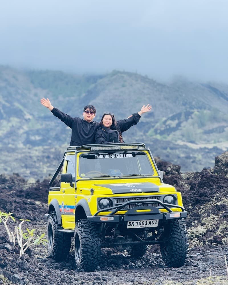 Couple cheering from a yellow jeep on the lava trail