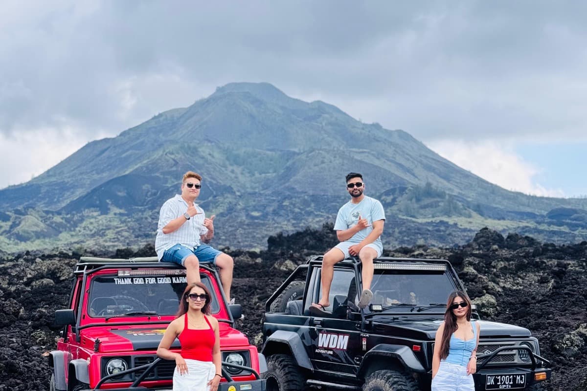 Two 4x4 jeeps and travellers on the black lava fields