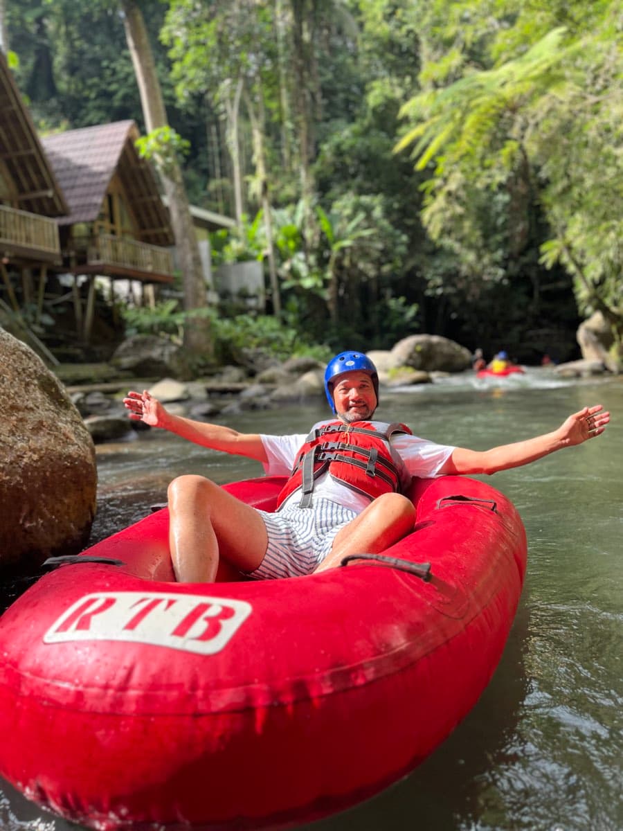 A rider leans back relaxed in the tube on a calm jungle pool