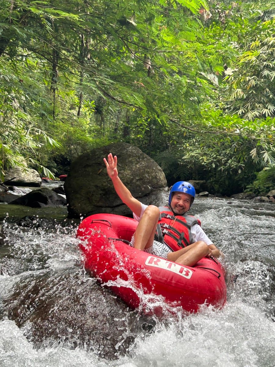 A rider flashes a peace sign while spinning through the rapids